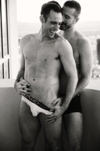 LGBTQIA+ couples boudoir shoot topless couple in underwear black and white