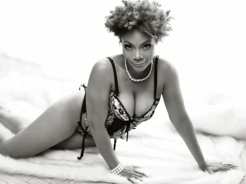 B&W classy BIPOC model with natural hair on furs wearing pearls and black lingerie curves
